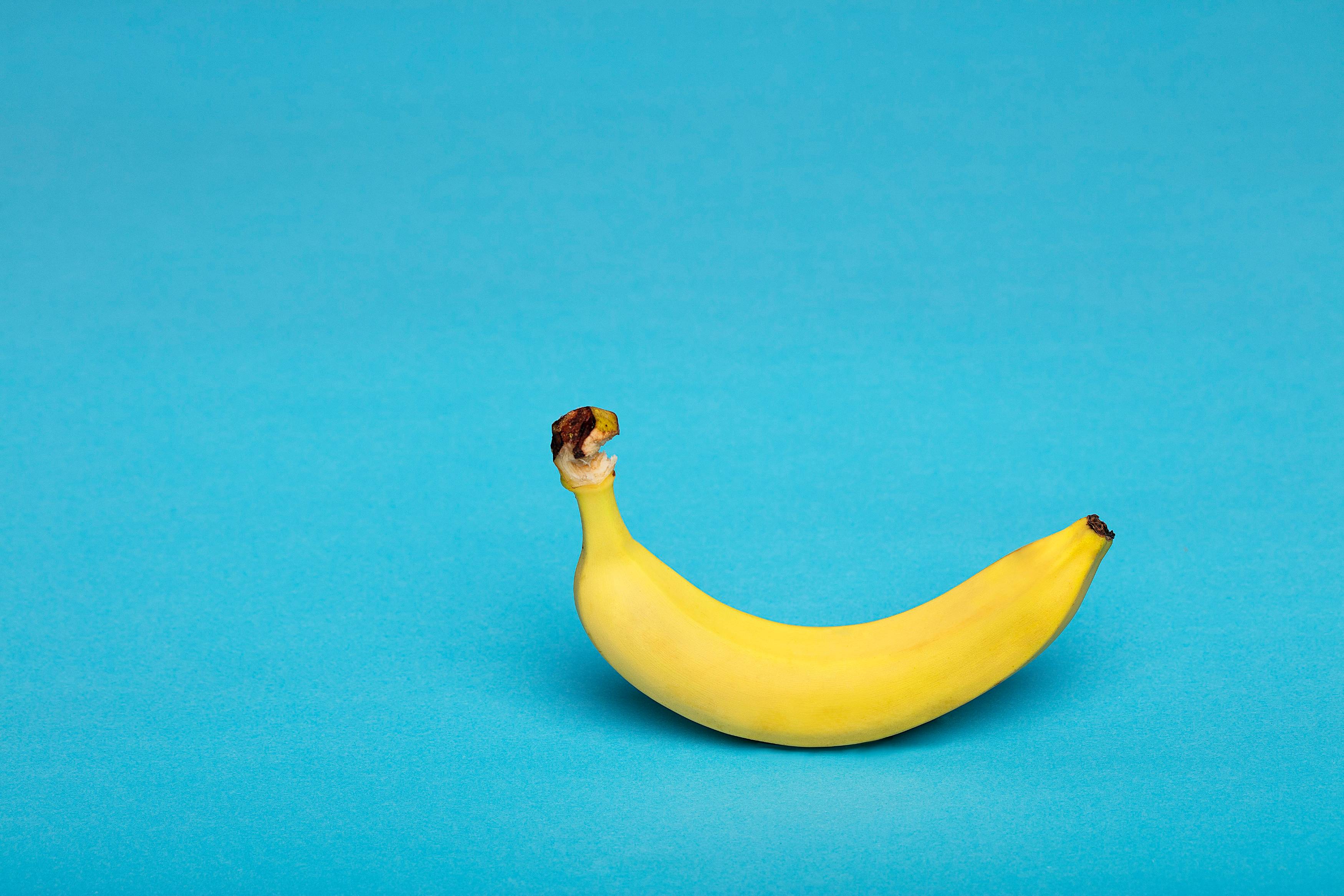 yellow banana fruit on blue surface
