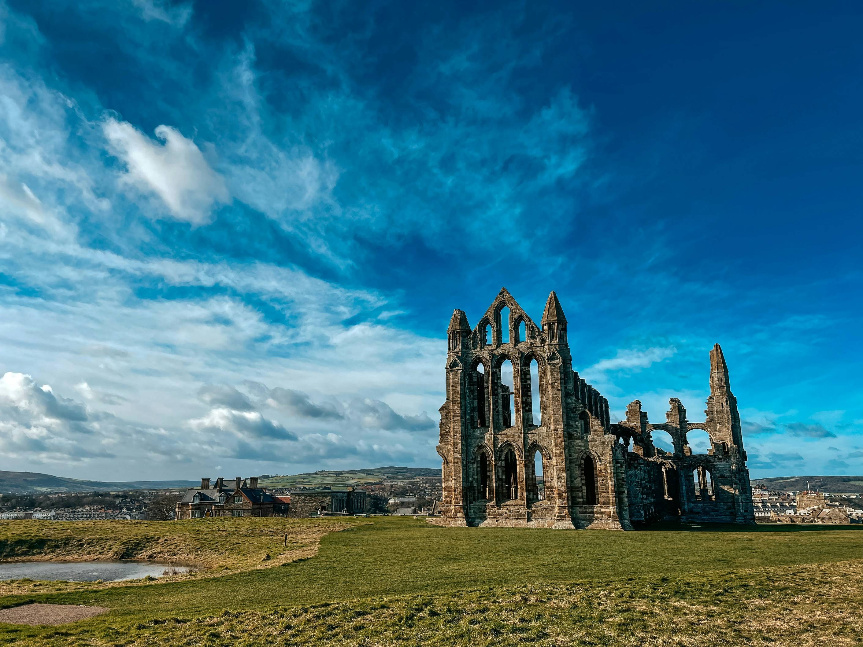 a large stone building sitting on top of a lush green field