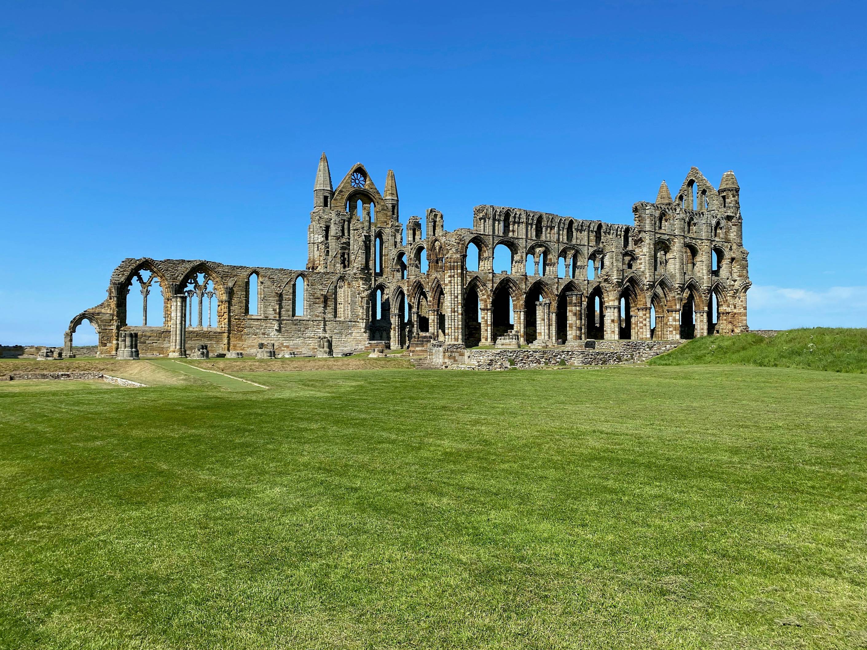 a large stone building sitting on top of a lush green field